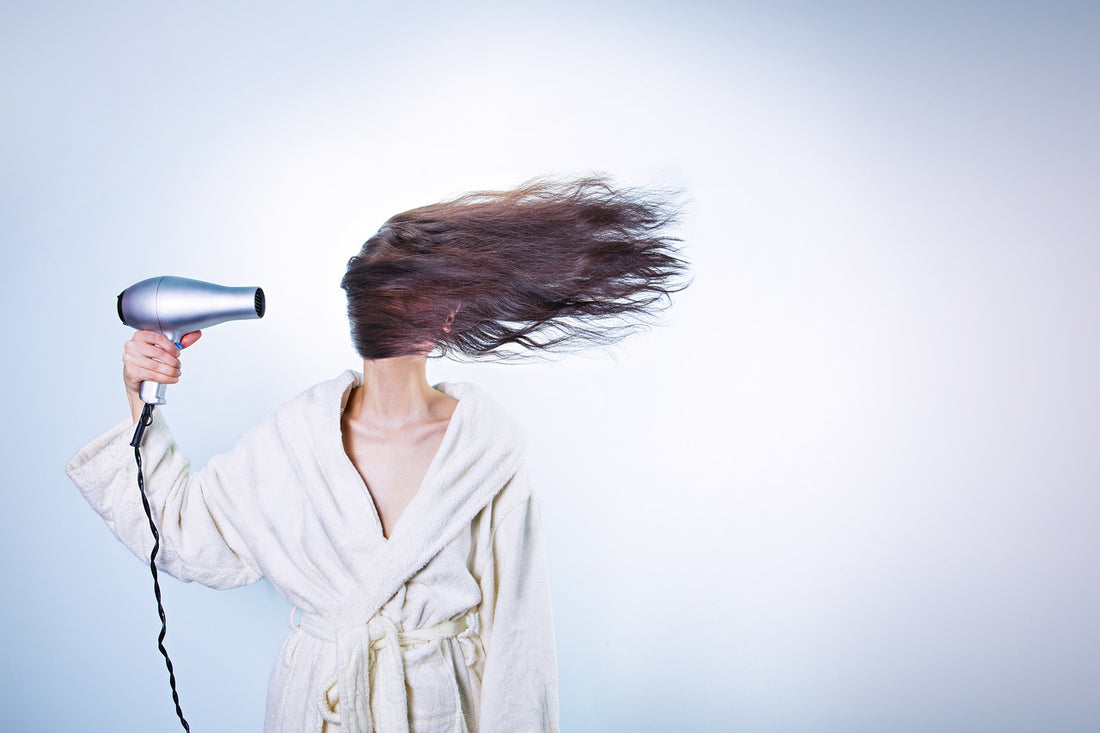 Woman blowing dry hair after using sea moss gel